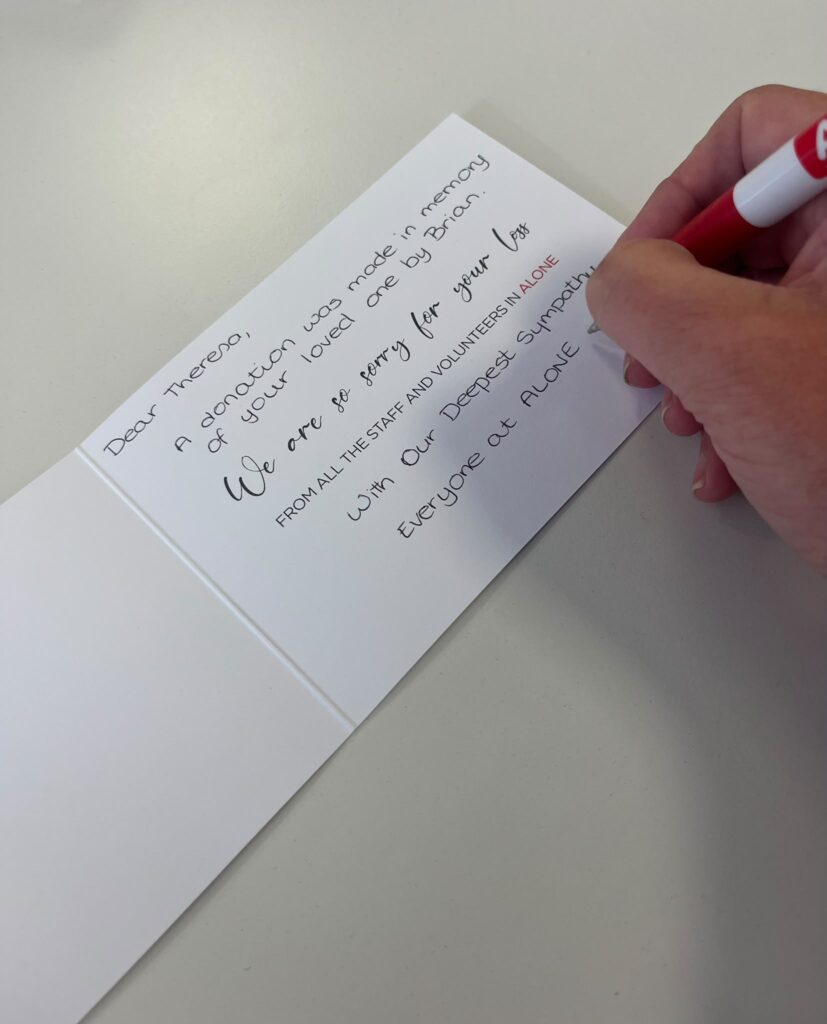 A person signing a card