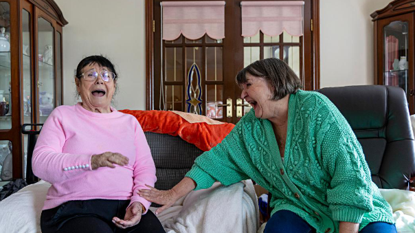 ALONE Volunteer image of ALONE Volunteer sitting on the couch talking with the person they visit
